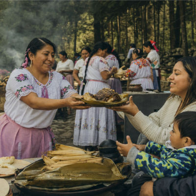 Cocinera tradicional mexiquense entrega un platillo a una familia durante una muestra gastronómica al aire libre en La Marquesa.
